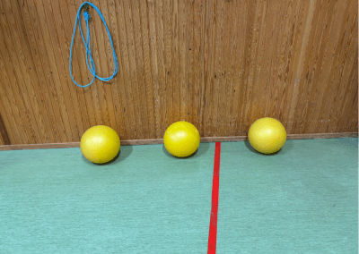 Hinderbana i gympasal – En station med tre bollar som tränar balans, koordination och kroppsuppfattning. Barnen kan rulla, hoppa eller balansera på bollarna.